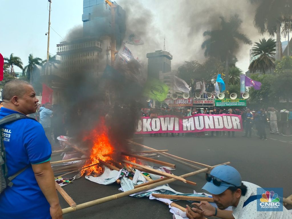 Buruh melakikan aksi bakr-bakaran saat demo di Patung Kuda, Monas, Jakarta, Senin (2/10/2023). (CNBC Indonesia/Martyasari Rizky)