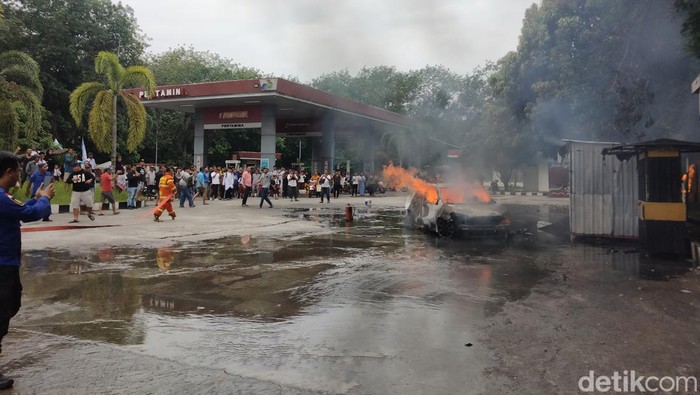 Foto: Petugas pemadam saat berusaha memadamkan api dari mobil yang terbakar di SPBU Kisaran. (Perdana Ramadhan / detikSumut).