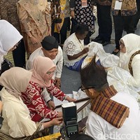 Tiba di stan perkumpulan pembatik asal Sumatera Barat, Wury diminta untuk menandatangani sebuah kain yang dihiasi batik bergambar Jam Gadang. Rustam Rusdi, pengamat sejarah yang turut mengorganisir kedatangan para perajin asal Minangkabau secara mandiri di kegiatan perayaan Hari Batik Nasional 2023 ini, membantu memegang figura kain tersebut. Sungguh sebuah kehormatan, tadi Ibu Wury mau memberi apresiasi kepada kami dalam bentuk tanda tangan ini, kata Rustam kepada Wolipop. (Foto: Daniel Ngantung/detikcom)