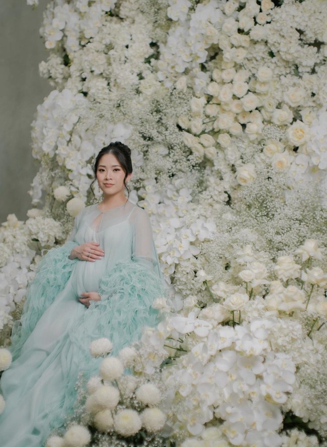 Pemotretan kehamilan Jessica itu juga semakin terlihat mewah dengan dekorasi yang dipenuhi dengan beragam bunga berwarna putih. Terlihat Jessica yang tampak cantik berpose di antara bunga-bunga tersebut. Foto: Instagram/@jessicatanoe