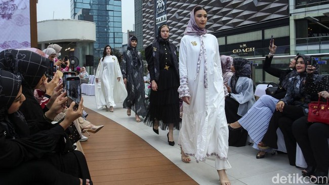 Sejumlah model berlenggak-lenggok memperagakan busana batik di Halte Tosari, Jakarta, Senin (2/10/2023).  