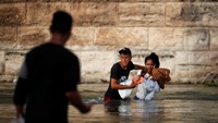 Migran asal Venezuela Elvis Faneite (23) membantu migran lain saat mereka menyeberangi Sungai Rio Grande.  