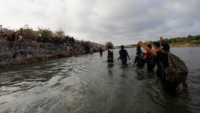 Migrants walk through the Rio Grande river in an attempt to seek asylum into the U. S., as seen from Piedras Negras, Mexico September 30, 2023. REUTERS/Daniel Becerril