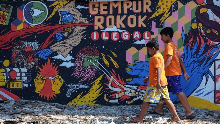 Warga melewati mural bertema Gempur Rokok Ilegal di Solo, Jawa Tengah, Senin (2/10/2023). Mural yang dibuat di 26 titik Kota Solo tersebut sebagai kampanye melawan peredaran rokok ilegal di masyarakat guna mencegah kerugian negara. ANTARAFOTO/Maulana Surya/rwa.