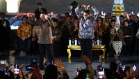 Mendagri Tito Karnavian (kiri) dan Menparekraf Sandiaga Uno dengan busana batik bergaya di atas catwalk dalam acara Istana Berbatik di depan Istana Merdeka, Jakarta, Minggu (1/10/2023). 