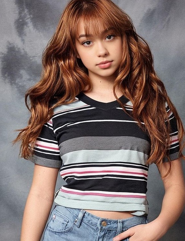 Di foto pertama, Rebecca Klopper tampak imut dengan kaos dan celana jeans. Filter buku tahunan versi AI tersebut menampilkan Rebecca dengan rambut panjang, curly dan berponi. Foto: dok. Instagram/@rklopper