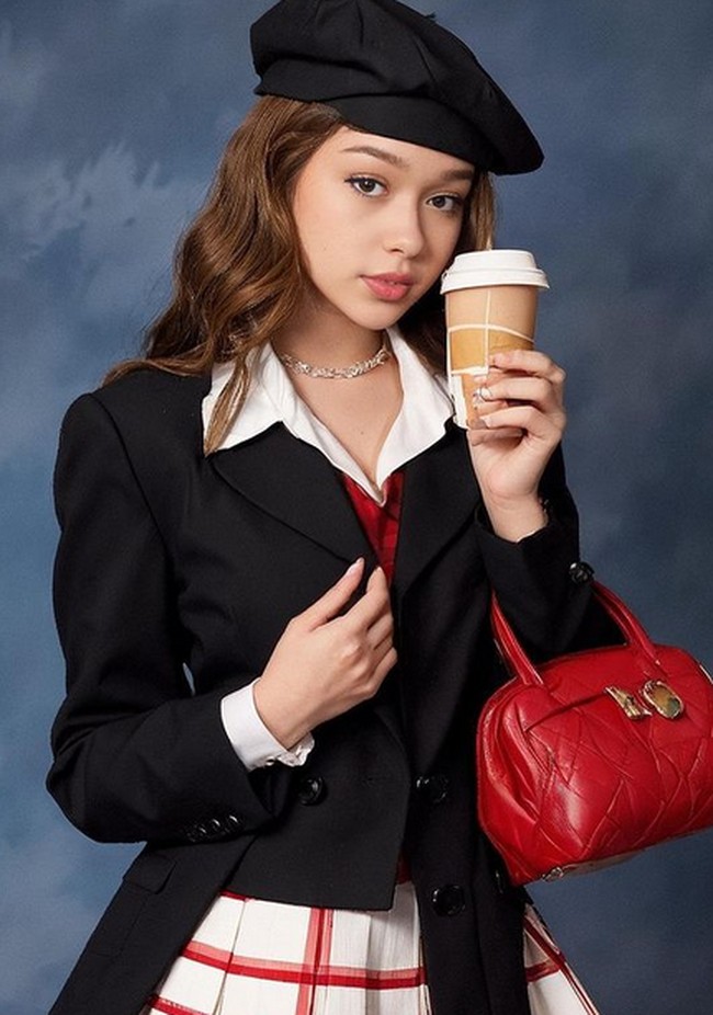 Ada foto AI Rebecca yang bergaya feminin dengan blazer dan tas merah yang ditenteng. Foto: dok. Instagram/@rklopper