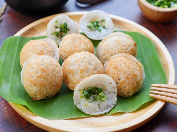 Kanom Krok yang lezat dan kenyal, dengan topping jagung manis dan daun bawang, siap untuk dinikmati selagi hangat