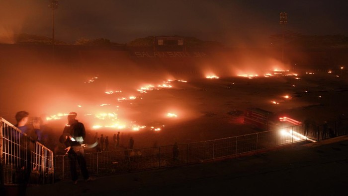 Rumput Stadion Kanjuruhan Terbakar Saat Malam Peringatan 1 Tahun Tragedi Sejumlah suporter menyaksikan rumput lapangan yang terbakar di Stadion Kanjuruhan, Malang, Jawa Timur, Minggu (1/10/2023). Dua unit mobil PMK Pemkab Malang dikerahkan untuk menangani kebakaran yang terjadi setelah aksi peringatan satu tahun Tragedi Kanjuruhan tersebut. ANTARA FOTO/Irfan Sumanjaya/rwa.