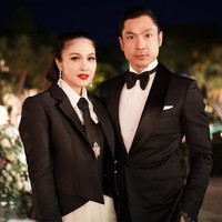 Ibu dua anak ini memakai bustier berbahan scuba yang dipadu blazer hitam rancangan desainer Cynthia Tan. Busana atasannya dipadankan dengan rok panjang berhias bordir. Dasi hadir sebagai pelengkap penampilan. Foto: Instagram/@sandradewi88