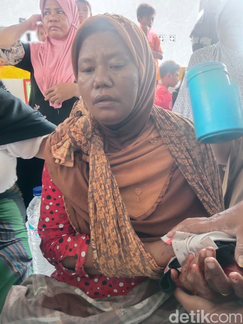 Seorang perempuan warga Pulau Rinca, TN Komodo, NTT, digigit komodo saat menjemur ikan di depan rumah.