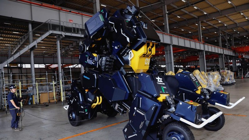 CEO Ryo Yoshida poses for a photograph with ARCHAX, a giant human-piloted robot developed by his start-up Tsubame Industries Co., in Yokohama, south of Tokyo, Japan September 27, 2023.  REUTERS/Issei Kato