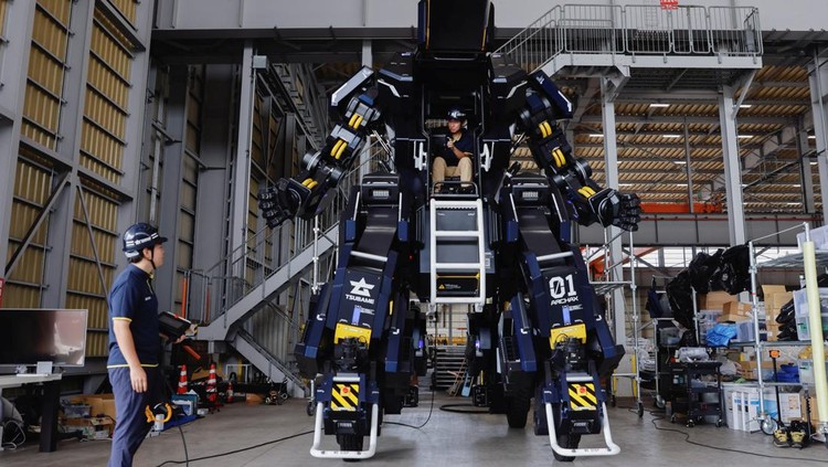 CEO Ryo Yoshida poses for a photograph with ARCHAX, a giant human-piloted robot developed by his start-up Tsubame Industries Co., in Yokohama, south of Tokyo, Japan September 27, 2023.  REUTERS/Issei Kato