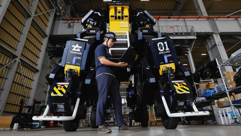 CEO Ryo Yoshida poses for a photograph with ARCHAX, a giant human-piloted robot developed by his start-up Tsubame Industries Co., in Yokohama, south of Tokyo, Japan September 27, 2023.  REUTERS/Issei Kato