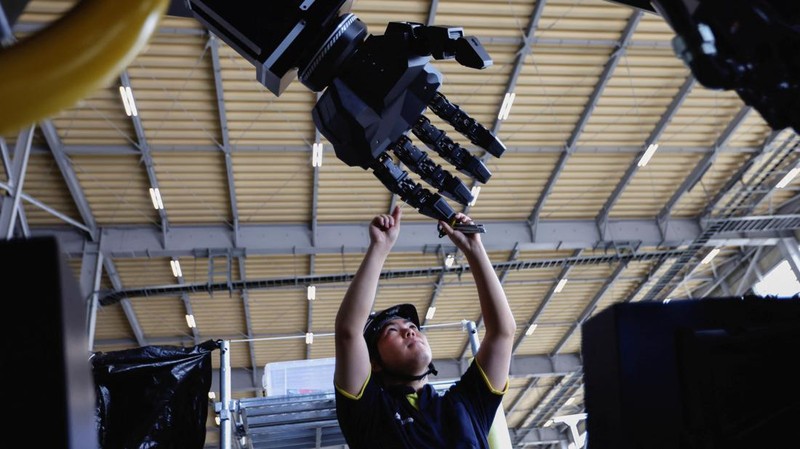 CEO Ryo Yoshida poses for a photograph with ARCHAX, a giant human-piloted robot developed by his start-up Tsubame Industries Co., in Yokohama, south of Tokyo, Japan September 27, 2023.  REUTERS/Issei Kato