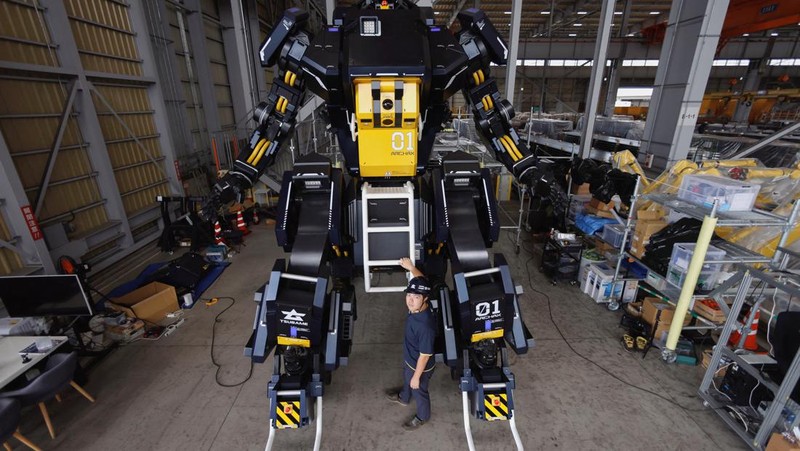 CEO Ryo Yoshida poses for a photograph with ARCHAX, a giant human-piloted robot developed by his start-up Tsubame Industries Co., in Yokohama, south of Tokyo, Japan September 27, 2023.  REUTERS/Issei Kato