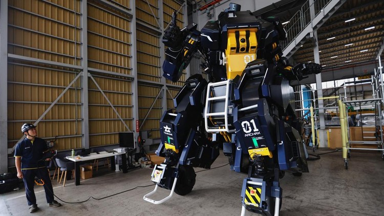 CEO Ryo Yoshida poses for a photograph with ARCHAX, a giant human-piloted robot developed by his start-up Tsubame Industries Co., in Yokohama, south of Tokyo, Japan September 27, 2023.  REUTERS/Issei Kato