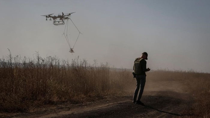 A member of the volunteer organization 'Postup' operates a drone with a metal detector for mine searching during demining a field, amid Russia's attack on Ukraine, near the town of Derhachi, Kharkiv region, Ukraine October 1, 2023. REUTERS/Sofiia Gatilova