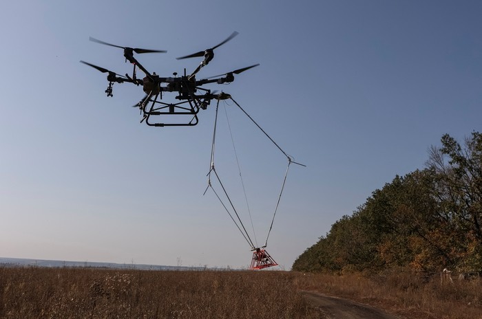 A member of the volunteer organization Postup operates a drone with a metal detector for mine searching during demining a field, amid Russias attack on Ukraine, near the town of Derhachi, Kharkiv region, Ukraine October 1, 2023. REUTERS/Sofiia Gatilova