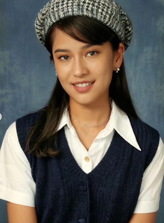 Dian Sastrowardoyo ikut tren AI Yearbook dengan menampilkan 10 foto versi jadul. Salah satunya memakai kemeja putih dengan vest biru dan topi pet. Wajahnya pun jadi seperti gadis remaja. Foto: Instagram/@therealdisastr