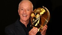 Aktor Anthony Daniels, yang memerankan C-3PO dalam 11 film Star Wars, berpose di samping topeng C-3PO yang menyala dan serasi dengan layar dari film Star Wars: A New Hope tahun 1977 yang merupakan bagian dari koleksi pribadinya. Topeng ini masuk dalam daftar barang yang akan dilelang.  