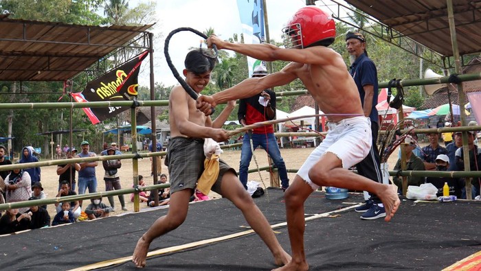 Petarung di Banyuwangi Saling Cambuk Saat Tradisi Meminta Hujan Petarung saling mencambuk lawannya dalam tradisi Tiban di Tamanagung, Cluring, Banyuwangi, Jawa Timur, Selasa (3/10/2023). Tradisi Tiban tersebut digelar sebagai tradisi meminta hujan saat musim kemarau. ANTARA FOTO/Budi Candra Setya/rwa.