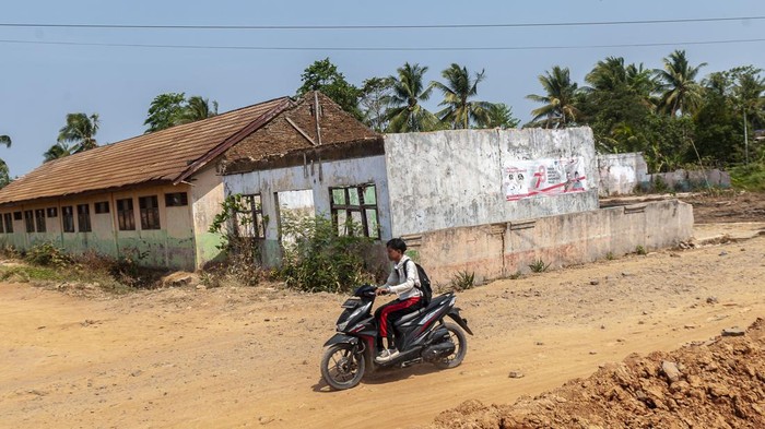 Sejumlah anak mengendarai motor melintasi SD Negeri Pasirkadu 1 di Pandeglang, Banten, Selasa (3/10/2023).  Sebanyak empat sekolah dasar yang berada di daerah tersebut terdampak gusuran pembangunan Tol Serang-Panimbang seksi III dan hingga kini belum ada bangunan pengganti untuk sarana belajar dari pemerintah. ANTARA FOTO/Muhammad Bagus Khoirunas/rwa.