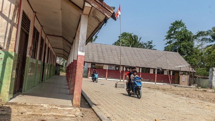 Sejumlah anak mengendarai motor melintasi SD Negeri Pasirkadu 1 di Pandeglang, Banten, Selasa (3/10/2023).  Sebanyak empat sekolah dasar yang berada di daerah tersebut terdampak gusuran pembangunan Tol Serang-Panimbang seksi III dan hingga kini belum ada bangunan pengganti untuk sarana belajar dari pemerintah. ANTARA FOTO/Muhammad Bagus Khoirunas/rwa.
