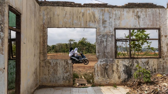 Sejumlah anak mengendarai motor melintasi SD Negeri Pasirkadu 1 di Pandeglang, Banten, Selasa (3/10/2023).  Sebanyak empat sekolah dasar yang berada di daerah tersebut terdampak gusuran pembangunan Tol Serang-Panimbang seksi III dan hingga kini belum ada bangunan pengganti untuk sarana belajar dari pemerintah. ANTARA FOTO/Muhammad Bagus Khoirunas/rwa.