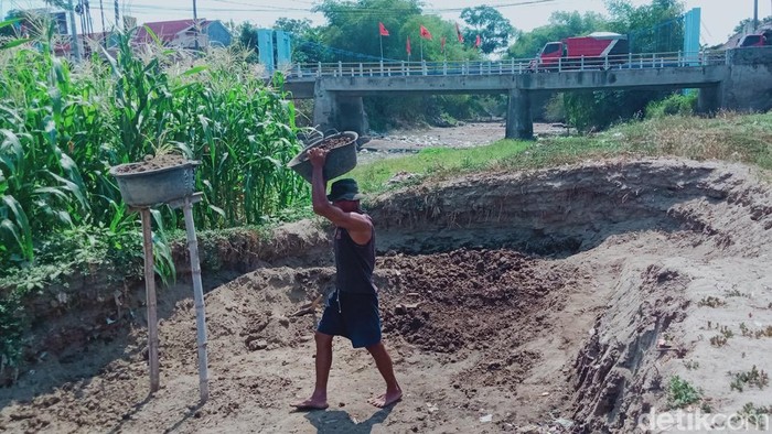 Warga Klaten mengeruk sedimentasi di Sungai Dengkeng, Selasa (3/10/2023).