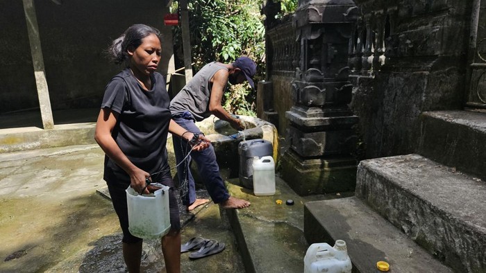 Warga menimba air di sumur tua di depan Pura Beji, tepatnya di perbatasan antara Desa Besan dan Desa Dawan, Klungkung, Bali, Selasa (3/10/2023). (Foto: Putu Krista/detikBali)