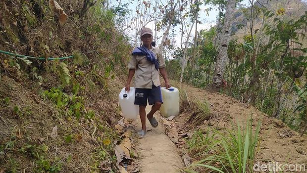 Warga Dusun Butuh, Desa Candirejo, Kecamatan Borobudur, Kabupaten Magelang ngangsu air bersih di mata air.