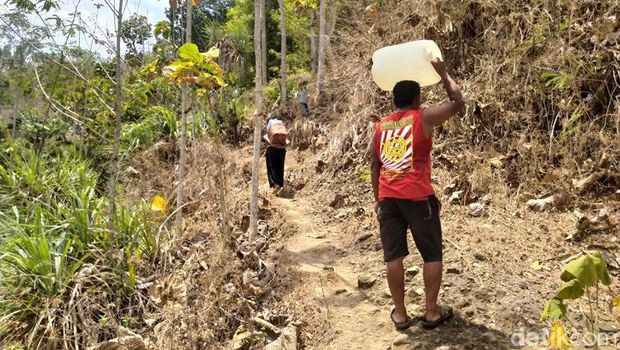 Warga Dusun Butuh, Desa Candirejo, Kecamatan Borobudur, Kabupaten Magelang ngangsu air bersih di mata air.