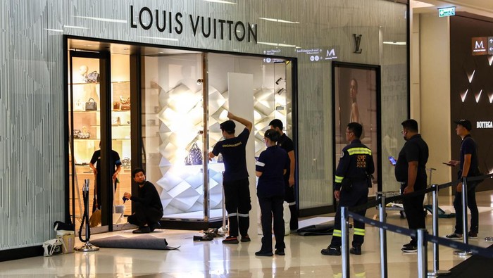Bagian Mal Siam Paragon yang Rusak Akibat Penembakan Mulai Diperbaiki Workers repair the glass door of a furniture store where a teenage gunman was arrested last night inside the luxury Siam Paragon shopping mall after killing foreigners and wounding other people in a shooting, in Bangkok, Thailand, October 4, 2023. REUTERS/Athit Perawongmetha