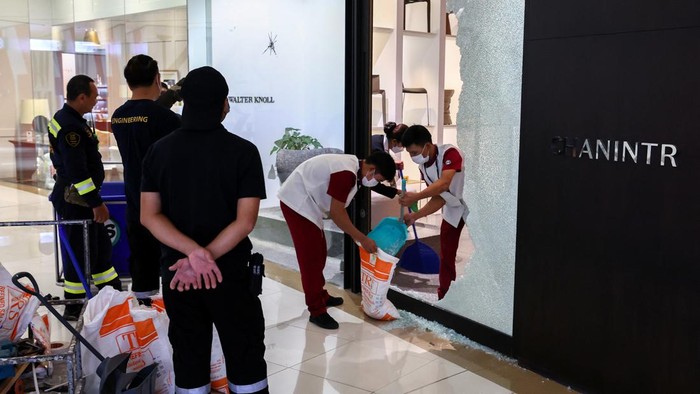 Bagian Mal Siam Paragon yang Rusak Akibat Penembakan Mulai Diperbaiki Workers repair the glass door of a furniture store where a teenage gunman was arrested last night inside the luxury Siam Paragon shopping mall after killing foreigners and wounding other people in a shooting, in Bangkok, Thailand, October 4, 2023. REUTERS/Athit Perawongmetha
