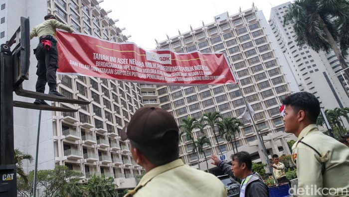 Sejumlah petugas Pusat Pengelolaan Komplek Gelora Bung Karno (PPKGBK) melakukan pemasangan spanduk di 15 titik area Hotel Sultan, Jakarta, Rabu (4/10/2023).  Tindakan ini dilakukan untuk meminta PT Indobuildco milik Pontjo Sutowo segera mengosongkan lahan Blok 15 di kawasan GBK tersebut.