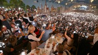 Orang-orang menyalakan kembang api dan menyanyi bersama saat hari terakhir Oktoberfest.  