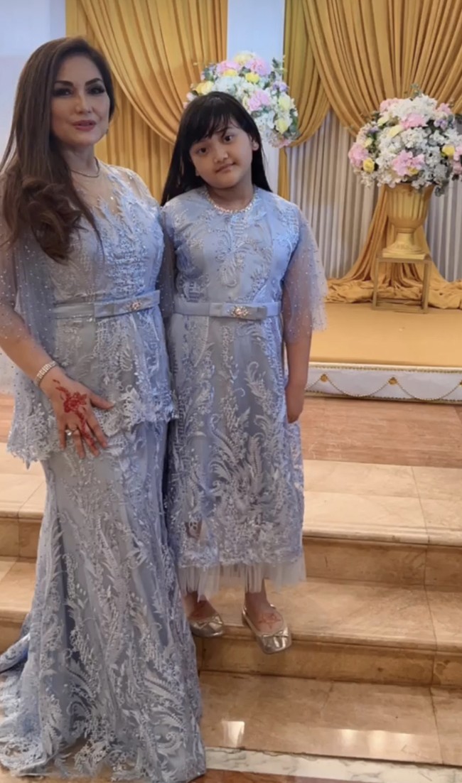 Tak jarang Nia Daniaty pergi ke pesta pernikahan dengan mengajak cucunya. Bahkan ia sengaja mengenakan busana kembar agar terlihat kompak dengan Shaakila. Foto: Instagram @niadaniatynew