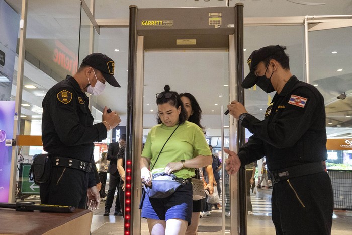 Security guards check a visitors bag before allowing them into the Siam Paragon Mall in Bangkok, Thailand, Wednesday, Oct. 4, 2023, a day after a teenage boy with a handgun opened fire inside the major shopping mall. (AP Photo/Wason Wanichakorn)