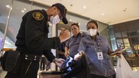 Petugas keamanan memeriksa tas pekerja sebelum mengizinkan mereka masuk ke mal. Laporan media-media lokal Thailand juga menyebut polisi telah menangkap seorang pria bersenjata yang menjadi tersangka dalam penembakan tersebut.