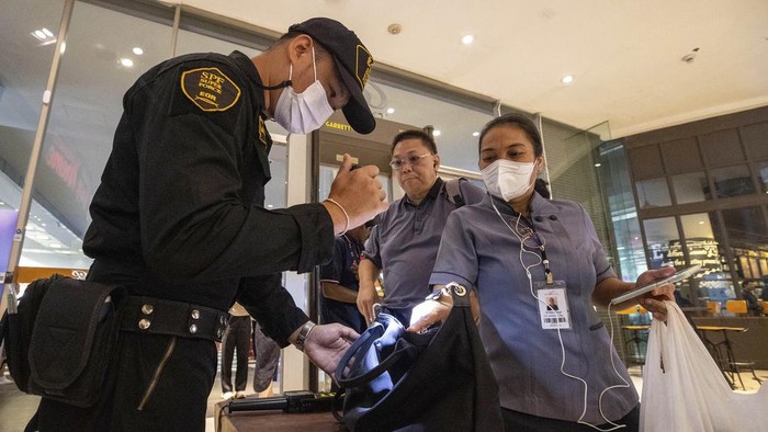 Pemeriksaan Pengunjung di Mal Siam Paragon Diperketat Pasca Penembakan Security guards check a visitor's bag before allowing them into the Siam Paragon Mall in Bangkok, Thailand, Wednesday, Oct. 4, 2023, a day after a teenage boy with a handgun opened fire inside the major shopping mall. (AP Photo/Wason Wanichakorn)