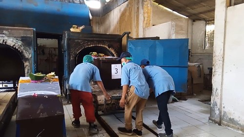 Petugas Krematorium Mumbul di Kuta Selatan, Badung, Bali, memasukkan jenazah ke dalam tungku kremasi, Rabu (4/20/2023). (Aryo Mahendro/detikBali)