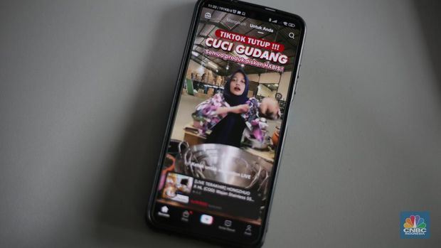Seorang pekerja melihat berbagai produk secara langsung di TikTokshop. (CNBC Indonesia/Tias Budiarto)