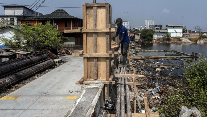 Tanggul Muara Baru Ditinggikan Antisipasi Pasang Air Laut Pekerja menyelesaikan proyek peninggian tanggul di kawasan Muara Baru, Jakarta, Selasa (3/10/2023). Pemprov DKI Jakarta melakukan peninggian tanggul di kawasan tersebut untuk mengantisipasi banjir air laut pasang atau rob. ANTARA FOTO/Aprillio Akbar/rwa.