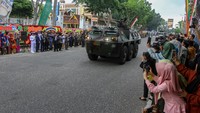 Sejumlah warga mengabadikan iring-iringan kendaraan tempur TNI saat peringatan HUT ke-78 di Pekanbaru, Riau, Kamis (5/10/2023). HUT ke-78 TNI mengangkat tema TNI Patriot NKRI, Pengawal Demokrasi untuk Indonesia maju. ANTARA FOTO/Rony Muharrman  