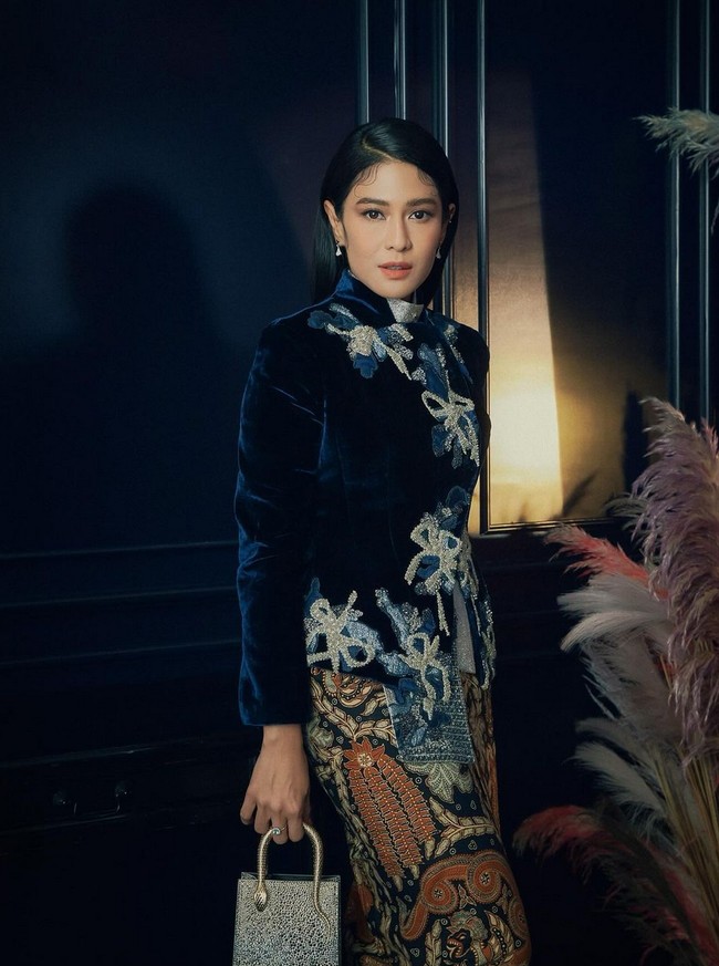 Dian Sastrowardoyo yang memerankan Dasiyah bergaya khas wanita Jawa dengan jaket beludru beraksen bordiran pita, dipadu kain batik klasik, rancangan Sapto Djojokartiko. Dian melengkapi penampilannya dengan clutch bling-bling dari Bulgari. Foto: Instagram/@therealdisastr