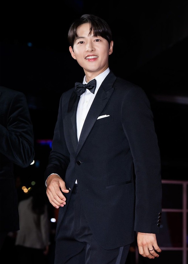 Song Joong Ki hadir di acara pembukaan Busan International Film Festival 2023, Rabu (4/10/2023), bersama pemain film Hwaran. Ayah satu anak itu tampil memakai setelan jas hitam keluaran Louis Vuitton. Foto: dok. Twitter @sjkwings1985