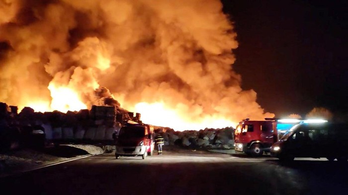 Firefighters stand near the fire at Drava International factory near Osijek, Croatia, October 4, 2023. REUTERS/Antonio Bronic