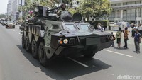 Prajurit TNI yang ada di kendaraan tempur terlihat melambaikan tangan. Ada pula yang menunjukkan pose finger heart ke warga yang antusias melihat parade.  