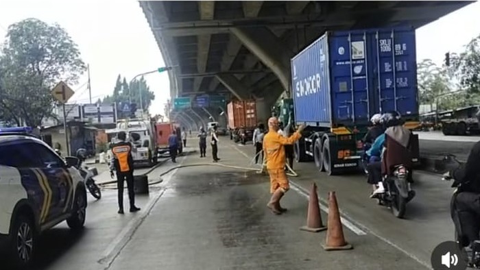 Petugas membersihkan tumpahan solar di Jalan Cakung-Cilincing, Jakarta Utara